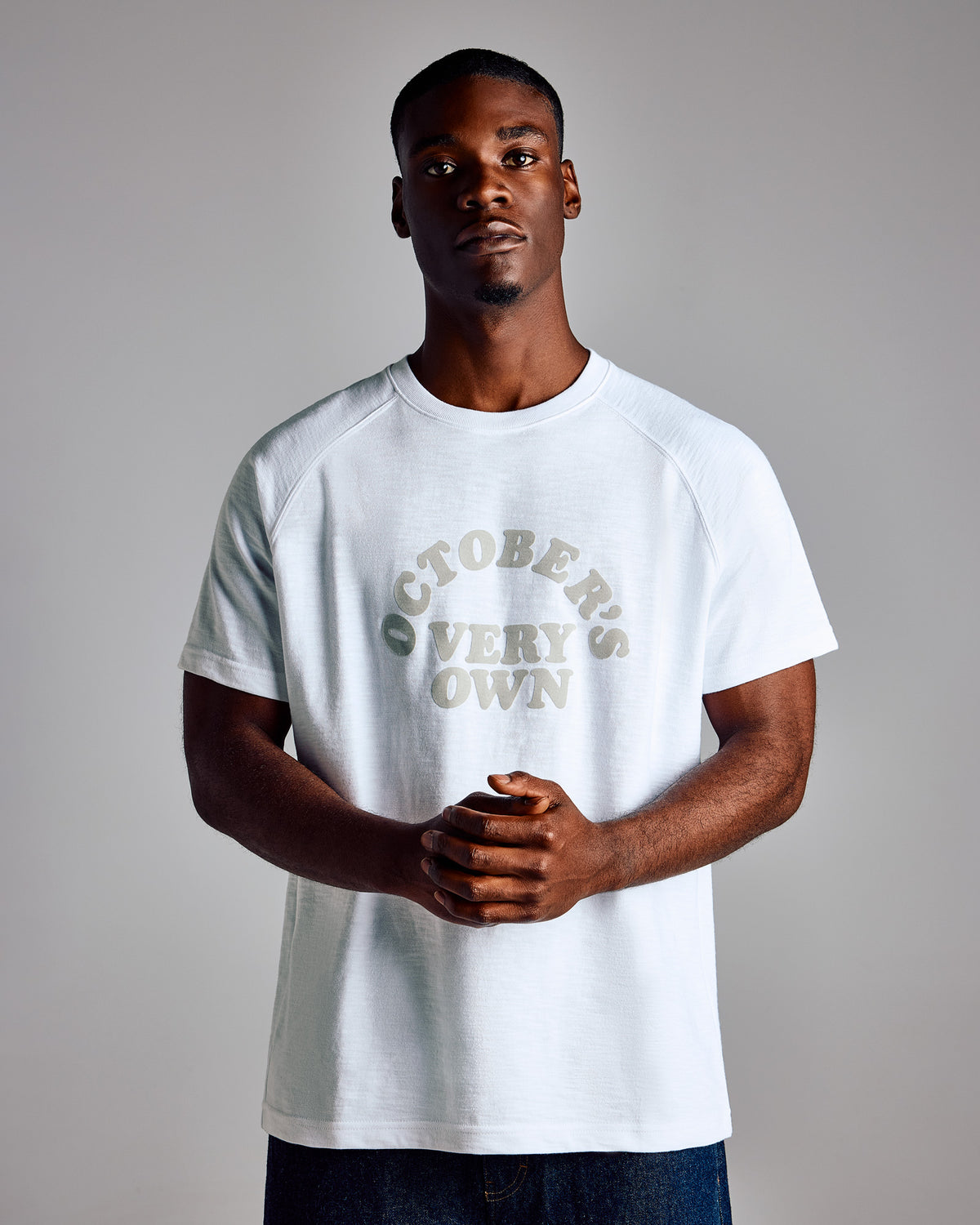 White short-sleeve raglan tee with "October's Own" text graphic on chest.