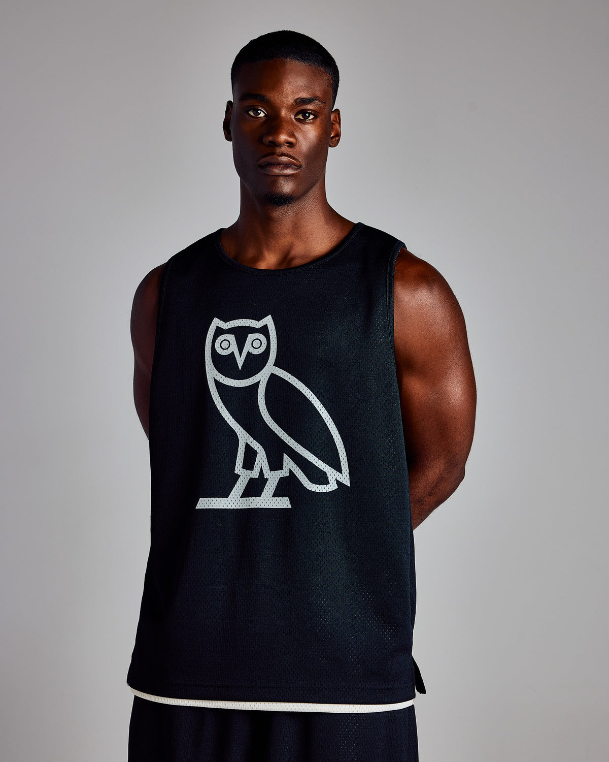 Black mesh basketball jersey with white owl graphic on chest and cream trim at hem.