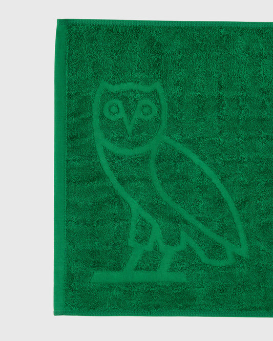 Green golf towel with embossed owl logo design.
