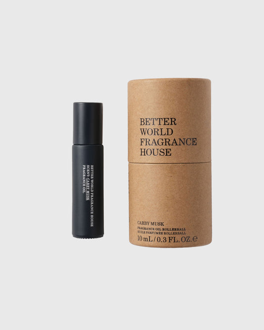 Black roller ball bottle with Better World Fragrance House Carby Musk fragrance oil next to kraft paper cylindrical packaging