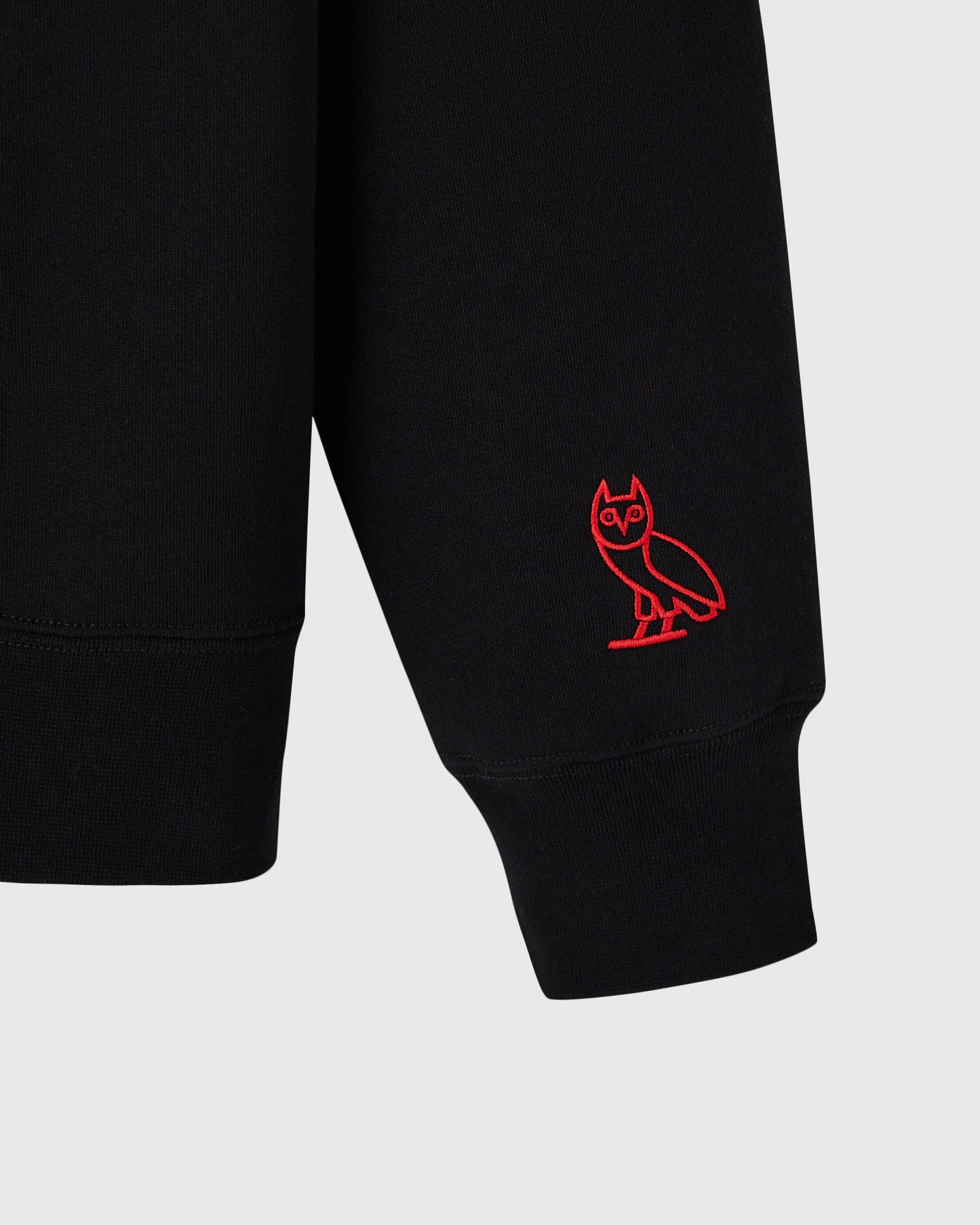Black crewneck sweatshirt with red bat graphic on sleeve.