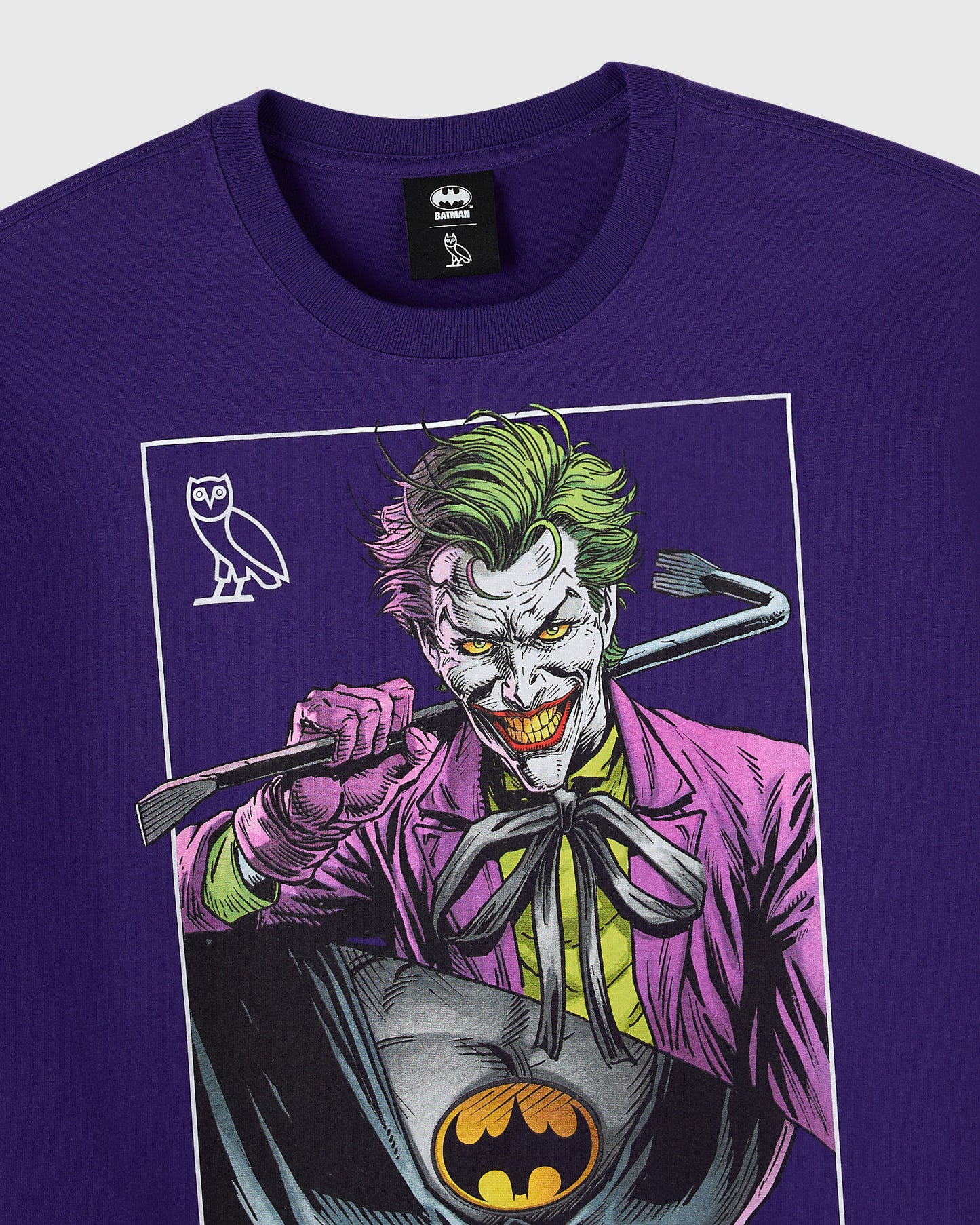 Purple t-shirt featuring split graphic design with Joker character on right side and Batman logo on left chest area.