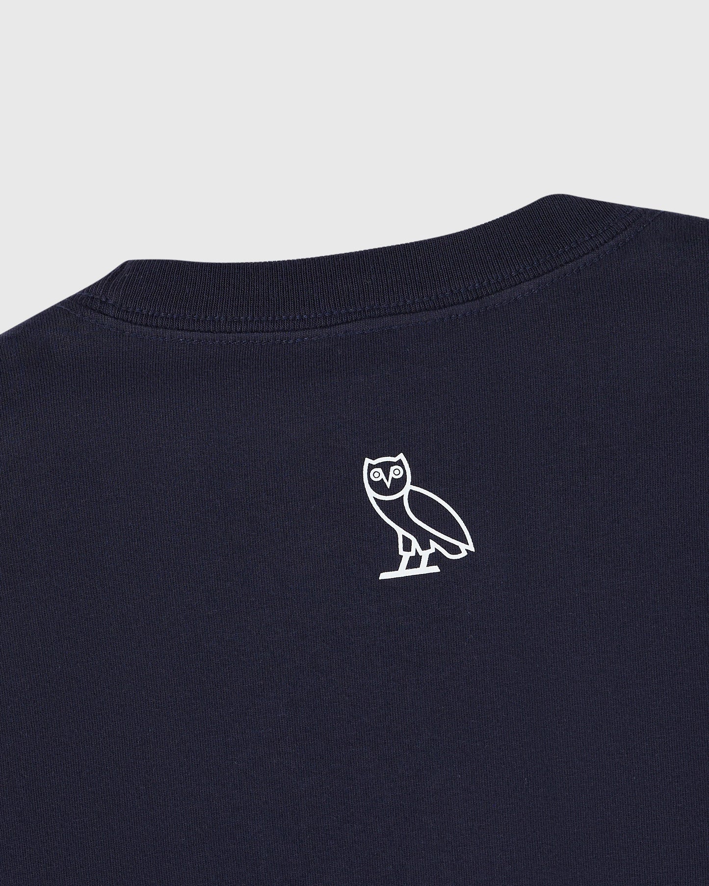 Navy blue t-shirt with small white owl outline graphic on chest.