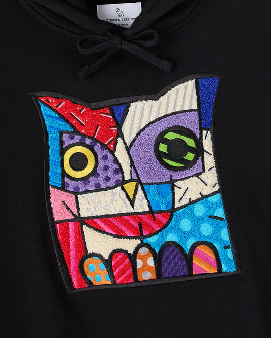 Black hoodie with colorful geometric owl graphic featuring multicolored embroidered sections and drawstring neckline.