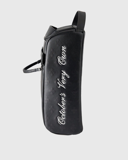 Black cylindrical golf bag with white monogram text and single shoulder strap.