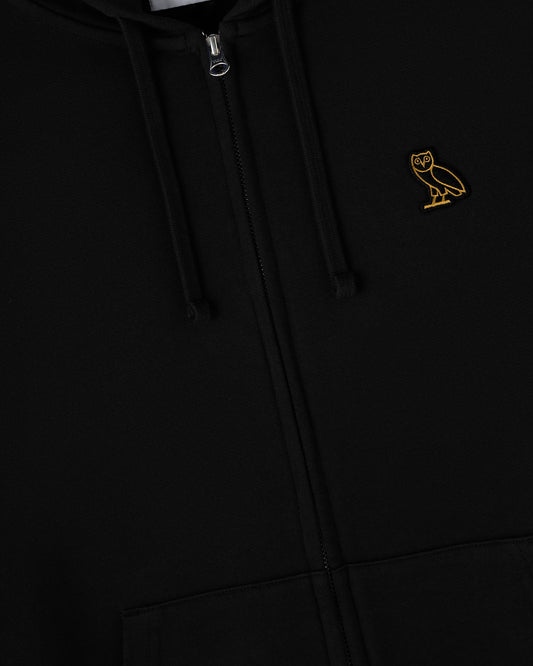 Black full-zip hoodie with metal zipper pull and small gold owl embroidery on chest.