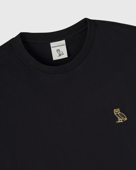 Black long-sleeve tee with crew neckline and small gold owl embroidery on chest.