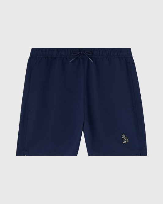 Navy blue swim shorts with drawstring waist and small embroidered bird logo on thigh.
