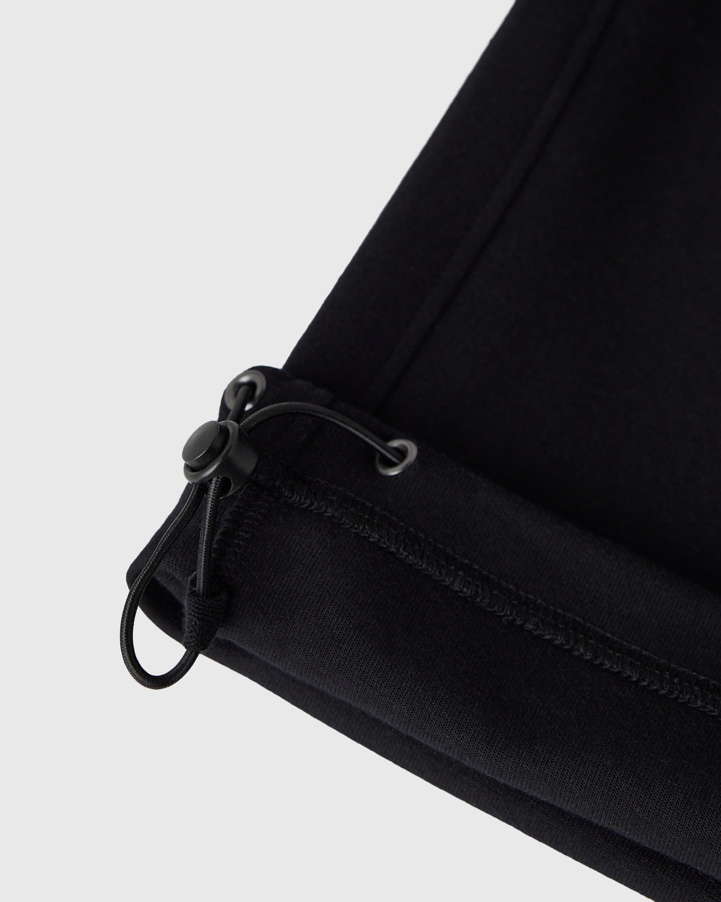 Black sweatpants with drawstring waistband and ribbed cuff detail.