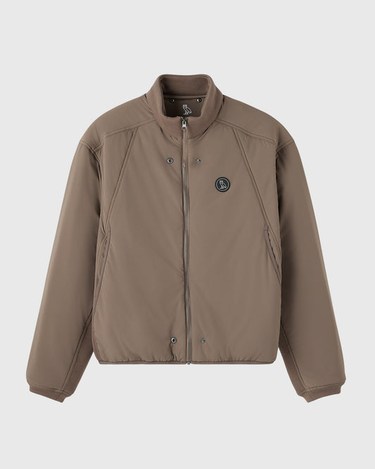 Mink-colored zip-up jacket with stand collar, snap button closure, and circular logo patch on chest.