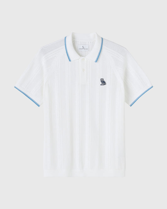 White open knit polo shirt with blue trim on collar and sleeves, small owl emblem on chest.