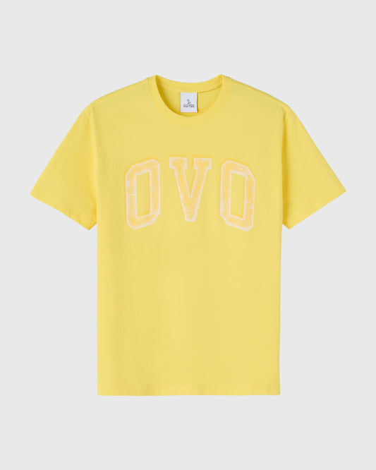 Yellow short-sleeve t-shirt with cream-colored arch graphic spelling "OVO" on chest.