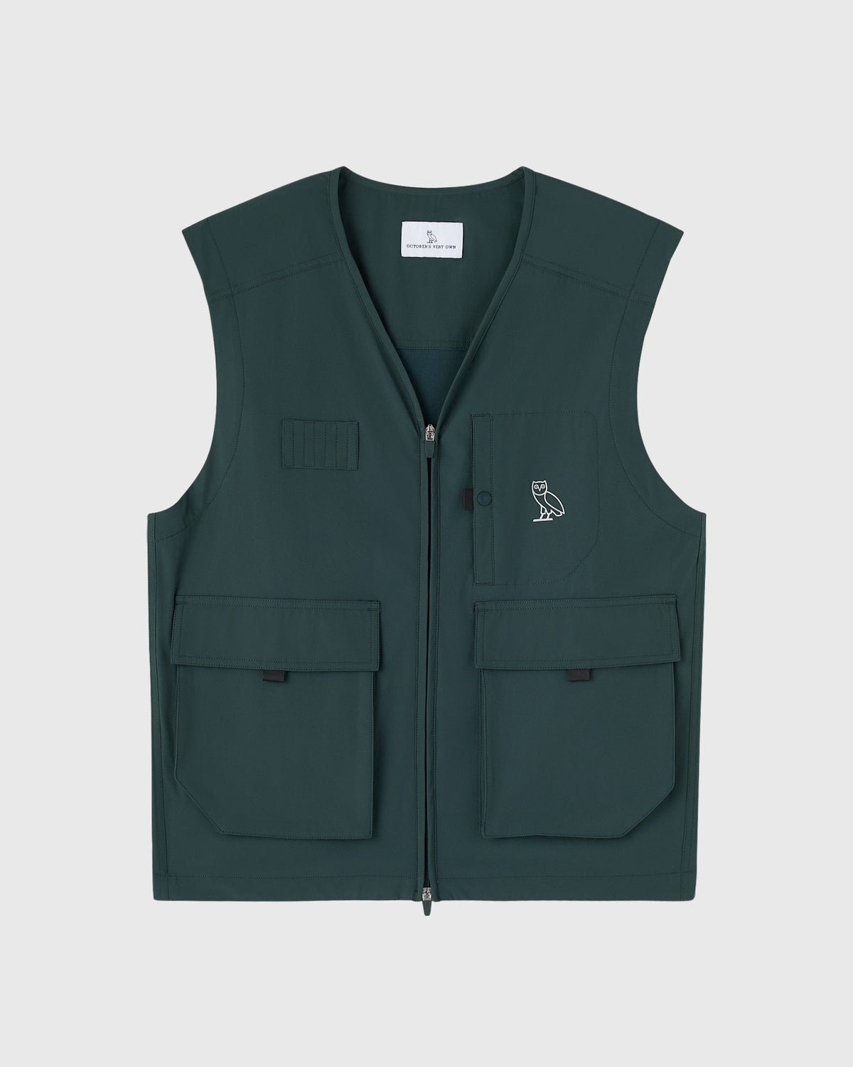 Midnight green stretch nylon vest with front zip, multiple pockets, and small owl embroidered logo on chest.