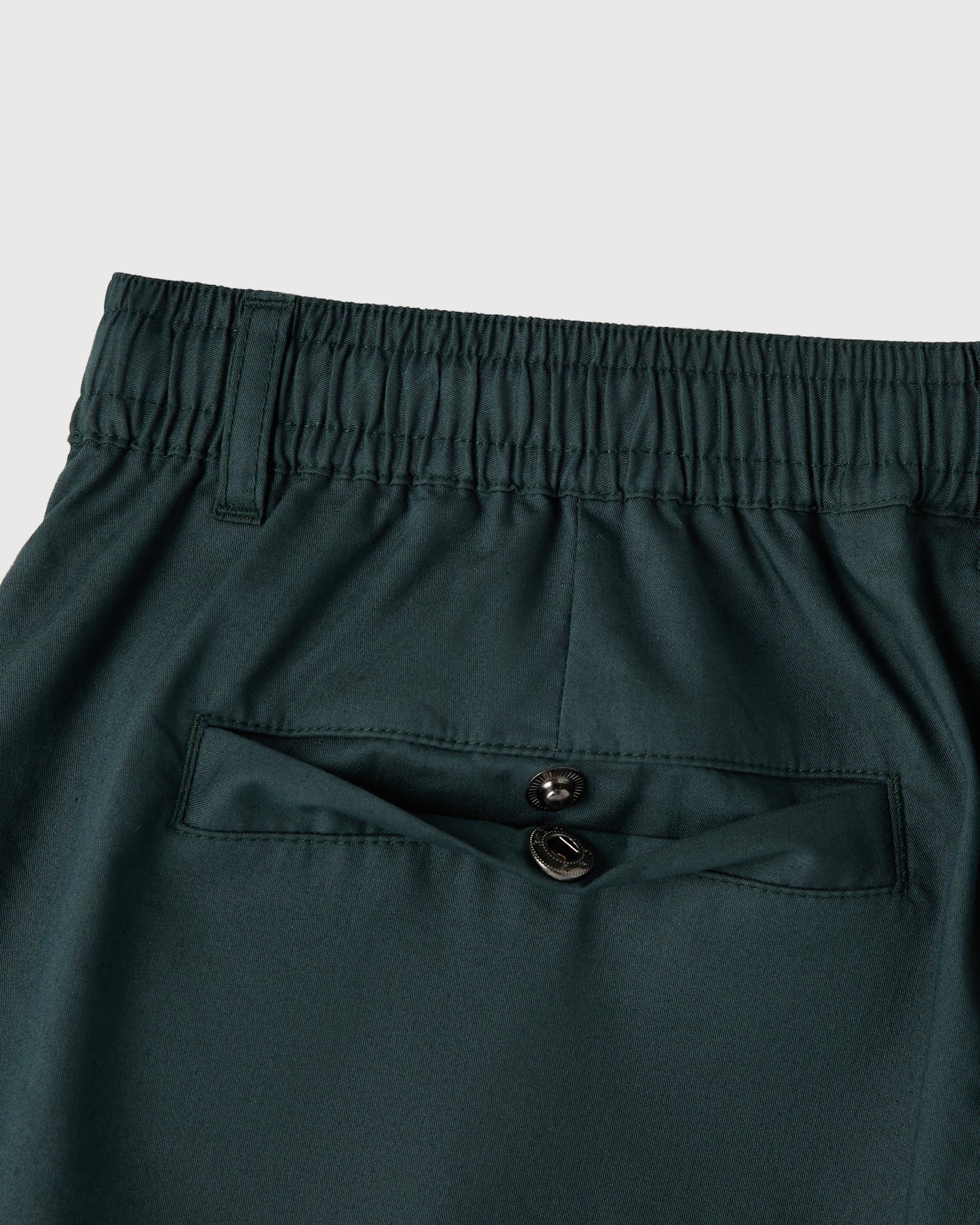Midnight green shorts with elastic waistband, drawstring, and front button pocket detail.
