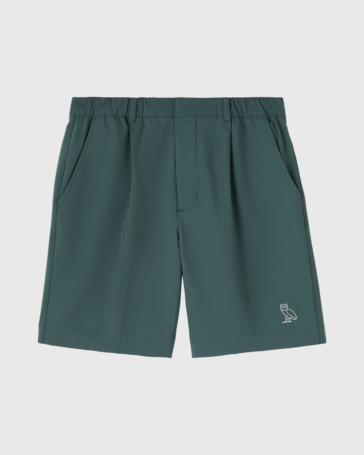Midnight green golf shorts with pleated front pockets, elastic waistband, and small owl logo on lower leg.