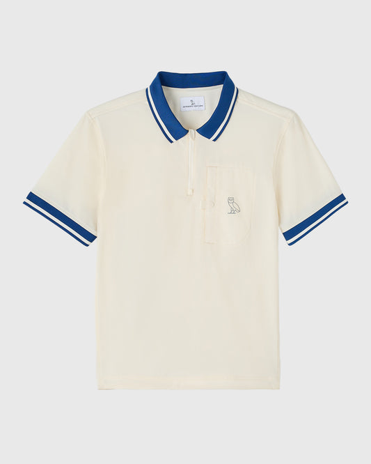 Cream polo shirt with blue and white striped collar and sleeve cuffs, featuring small owl embroidery on chest pocket.