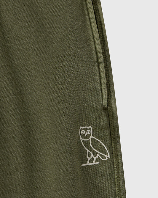 Cypress green sweatpant with ribbed texture and small white owl embroidery on leg.