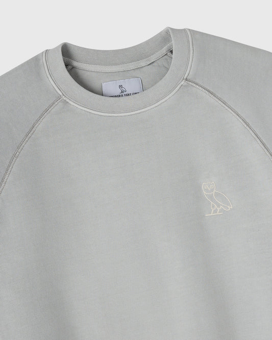 Gray crewneck sweatshirt with ribbed collar, raglan sleeves, and small owl embroidery on chest.