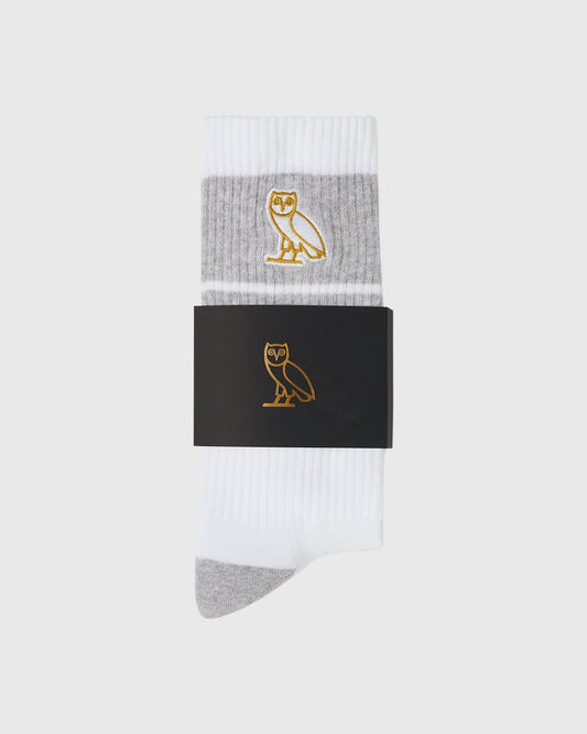White crew socks with gray heel and toe, featuring gold owl emblem on gray stripe band.