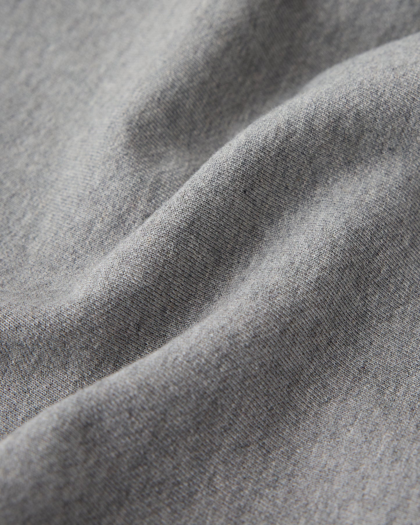 Heather grey sweatshort fabric showing textured weave and soft folds.