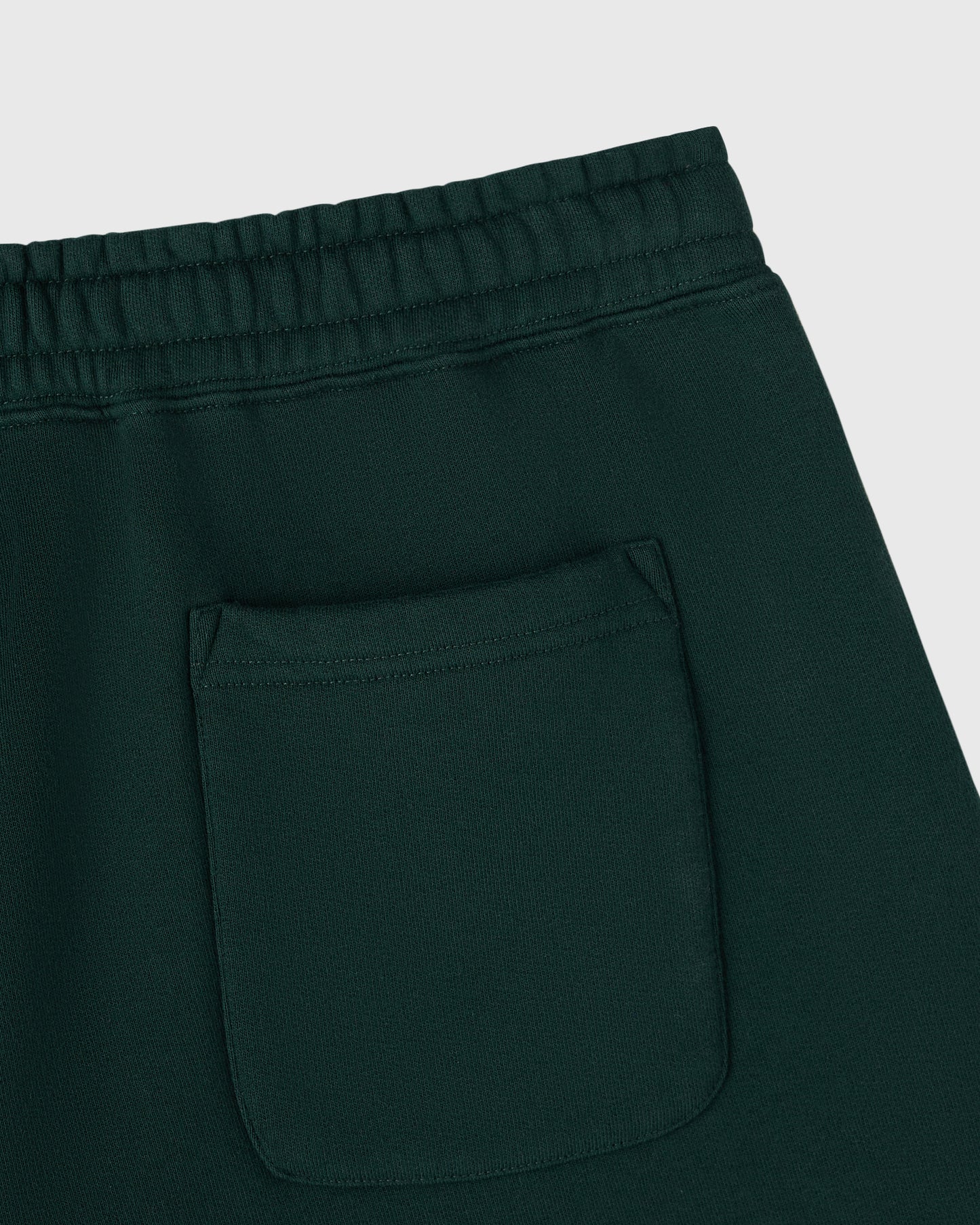 Midnight green shorts with ribbed waistband, drawstring, and front patch pocket.
