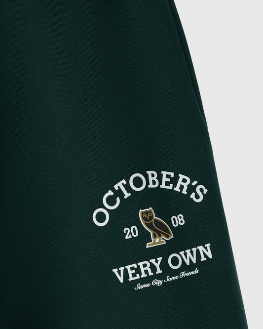 Midnight green sweatpant with white "October's Very Own" text and gold owl graphic on leg.