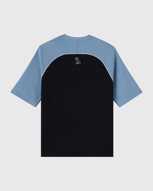 Black and blue colorblock raglan tee with small owl logo on chest.