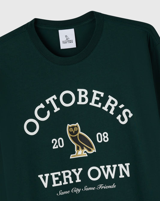 Midnight green long-sleeve tee with white text reading "October's Very Own," gold owl graphic, and "20 08" printed on chest.