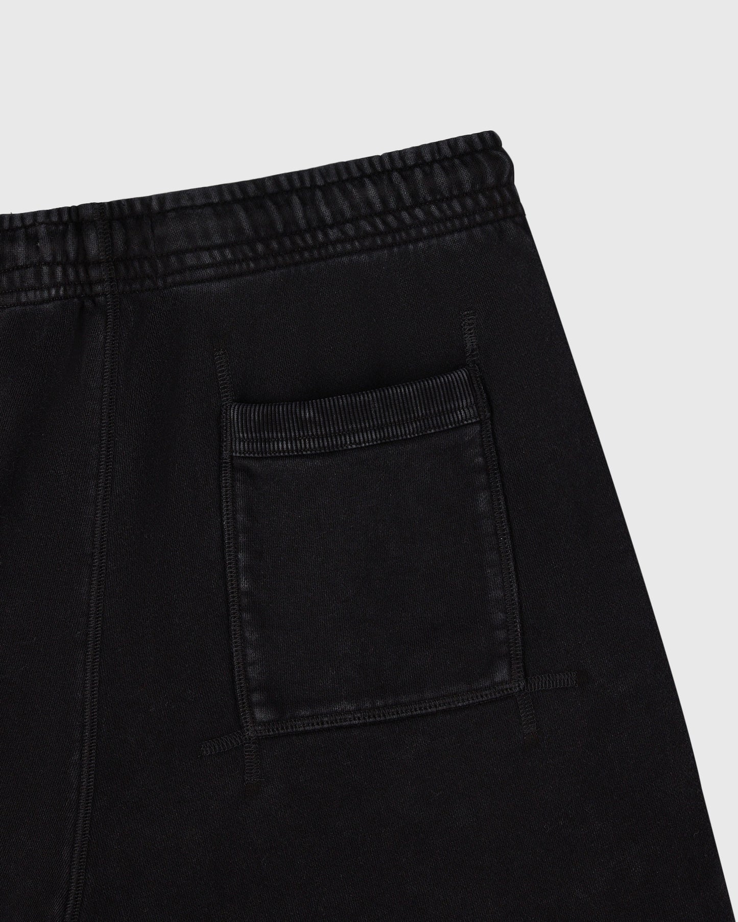 Black sweatshorts with elastic waistband and front patch pocket detail.