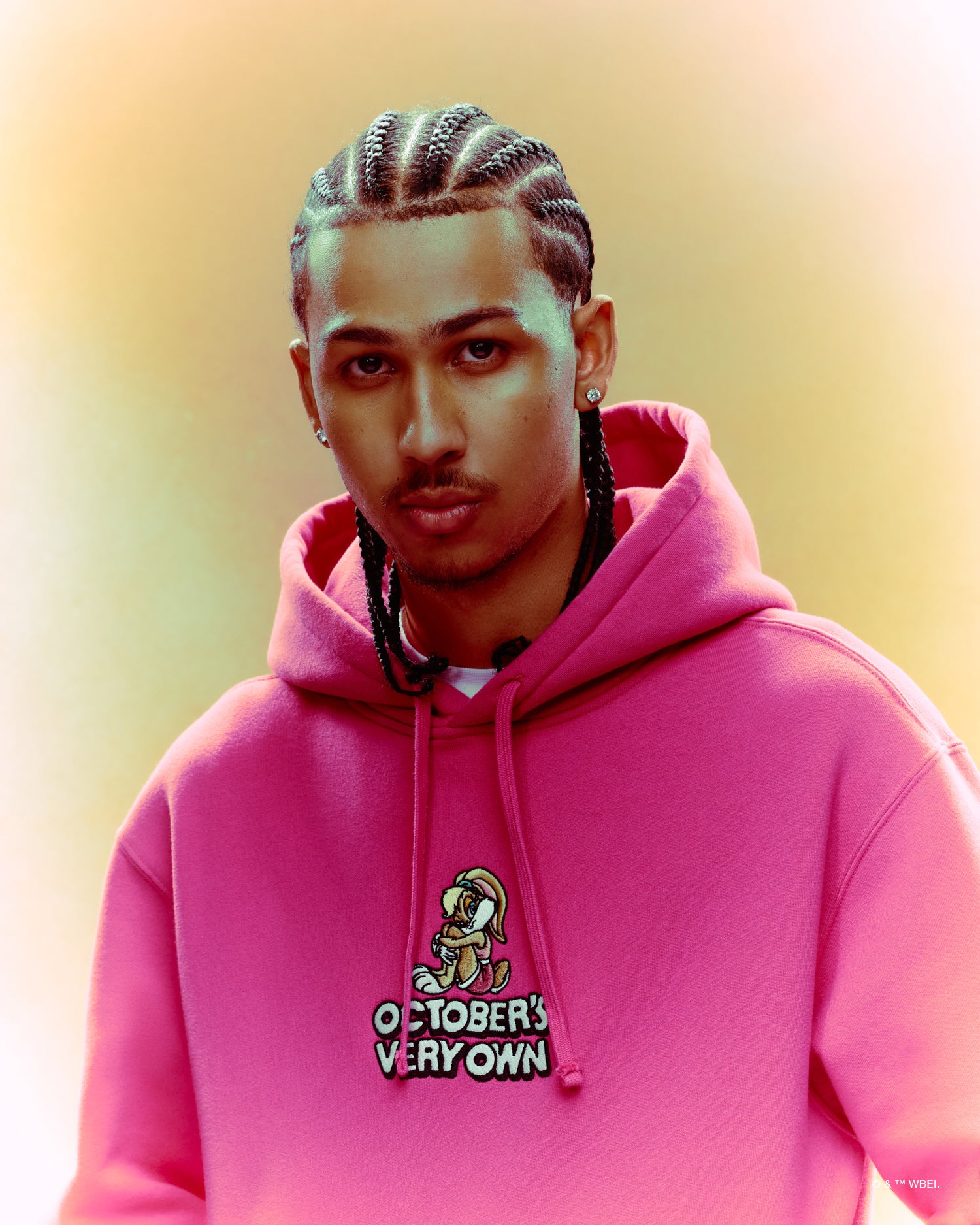 Person wearing a pink hoodie with 'October's Very Own' logo on a gradient background