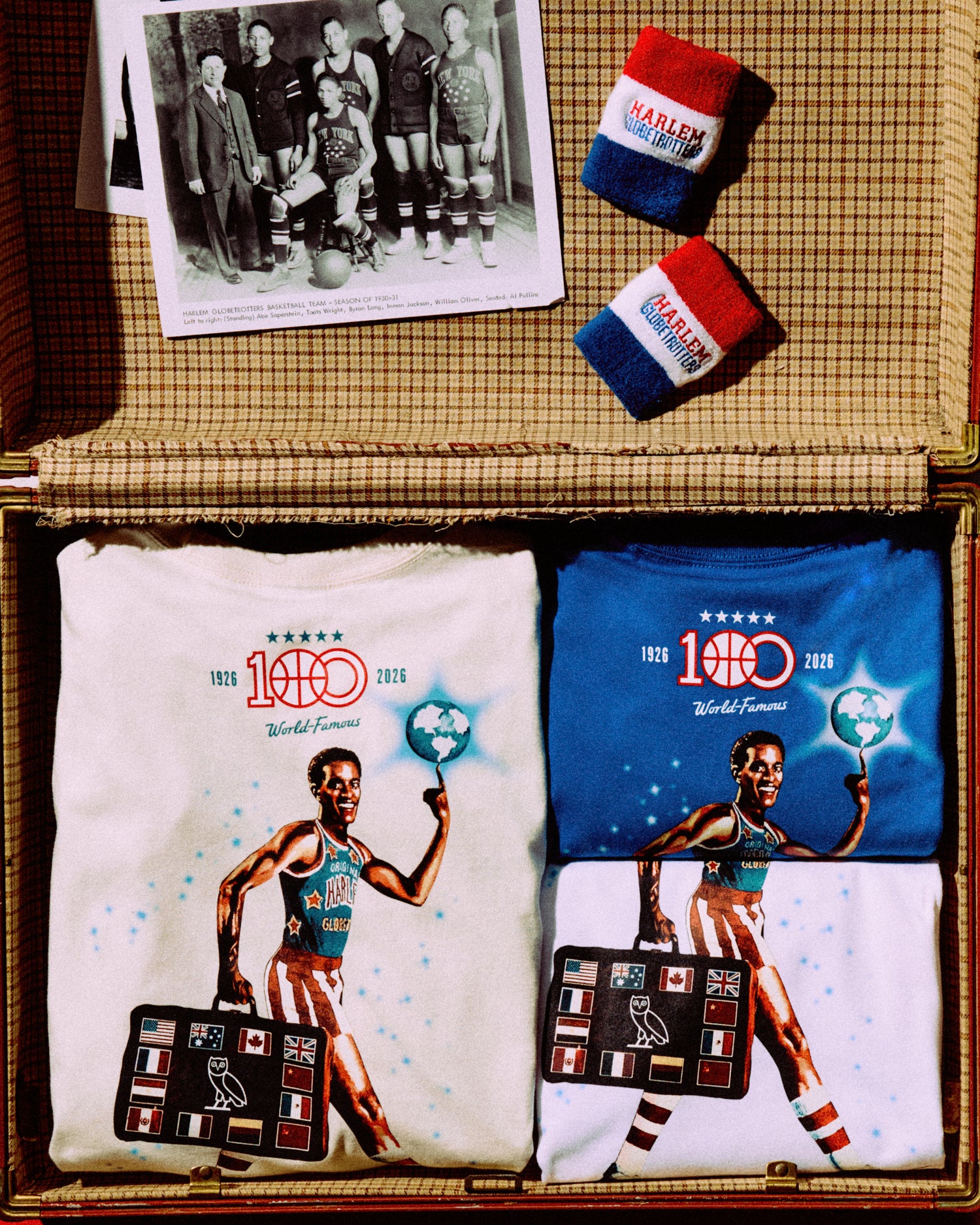 Two t-shirts with a Octobers Very Own x Harlem Globetrotters design and two socks on a checkered surface.