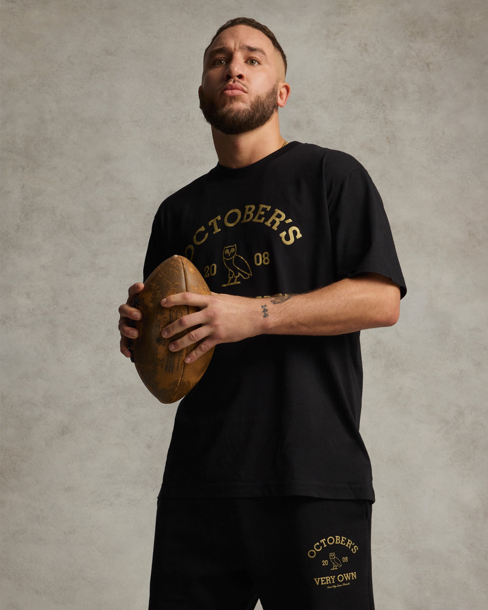 Black t-shirt with gold "Octobers 20 08" text and owl graphic on chest.