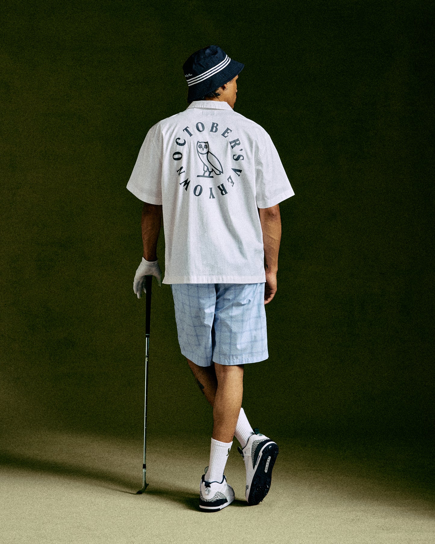 White camp shirt with circular wordmark and owl graphic on back.