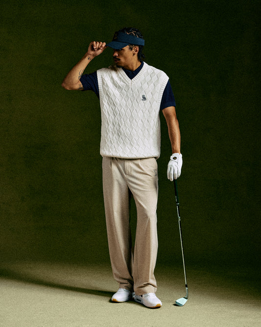 Sandstone chino pants on model wearing white golf glove and holding golf club.