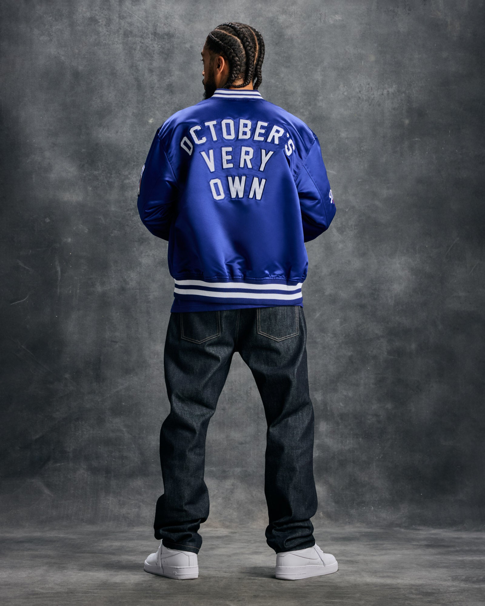 Blue varsity jacket with white "October's Very Own" text on back, white stripe trim at collar and cuffs.