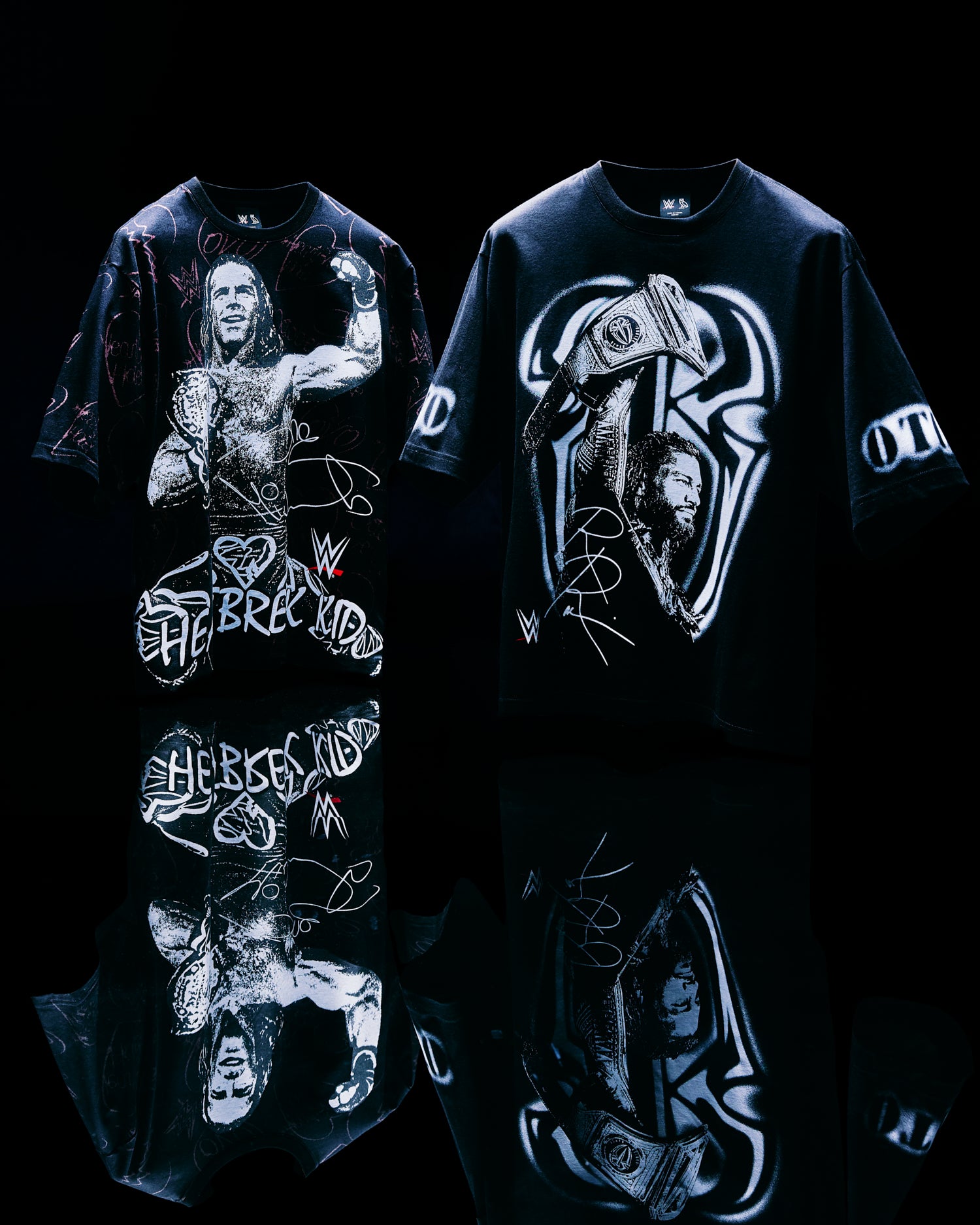 Two October's Very Own x WWE black t-shirts with graphic designs on a reflective black surface