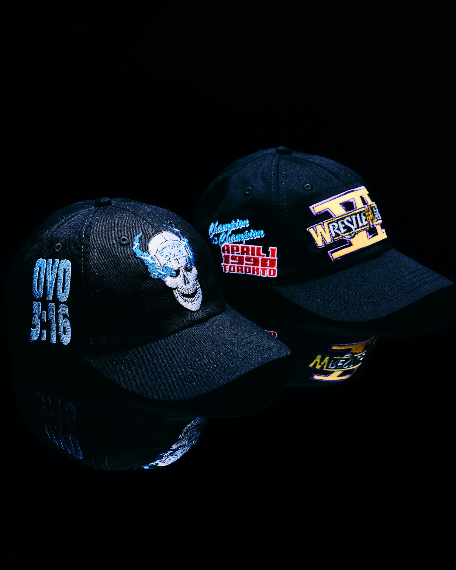 Two black October's Very Own baseball caps with embroidered designs on a black background