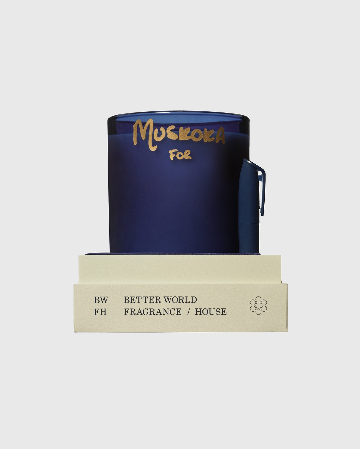 Dark blue cylindrical candle with gold "Muskoka" text and matching cream-colored branded box with handle.