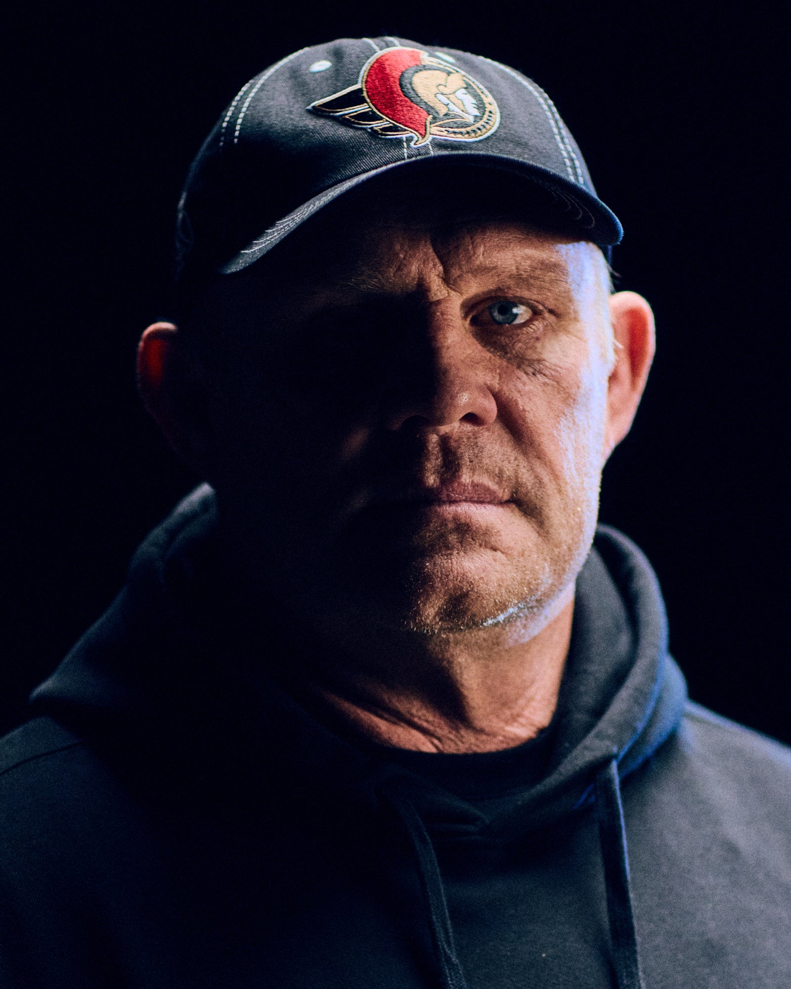 Man wearing a cap October's Very Own x NHL with a logo against a black background