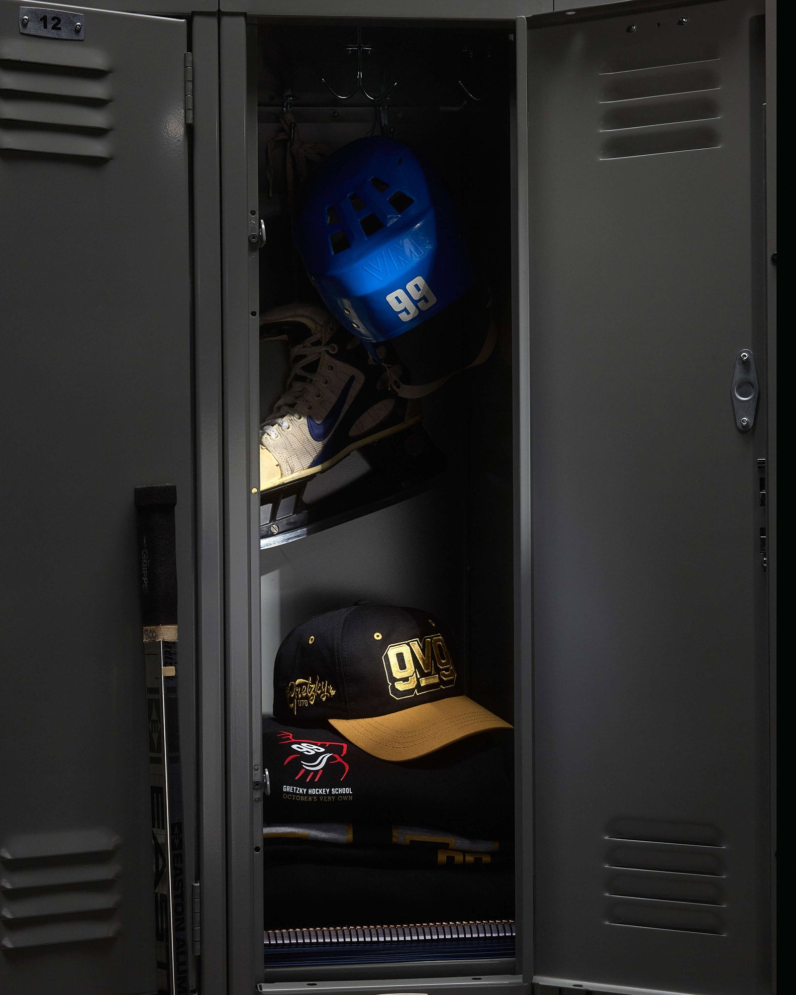 Open locker with sports equipment including a blue helmet and two caps.