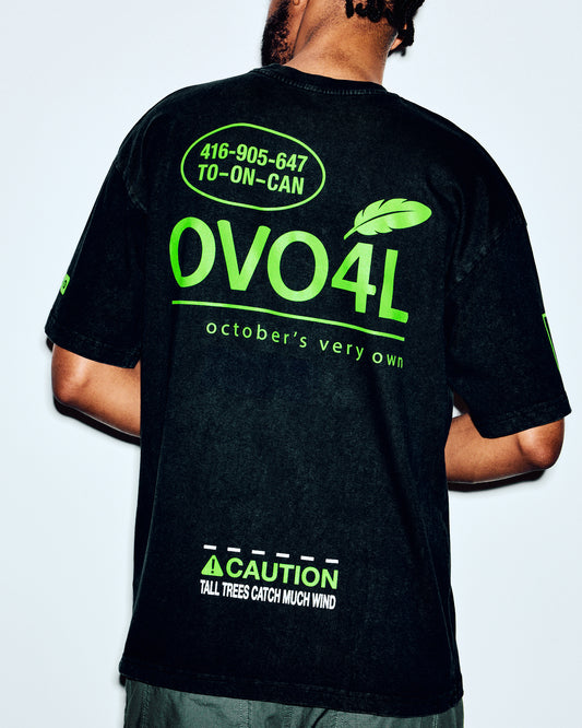 Black t-shirt with neon green back print including "OVO4L" text, feather graphic, phone number, and caution message.
