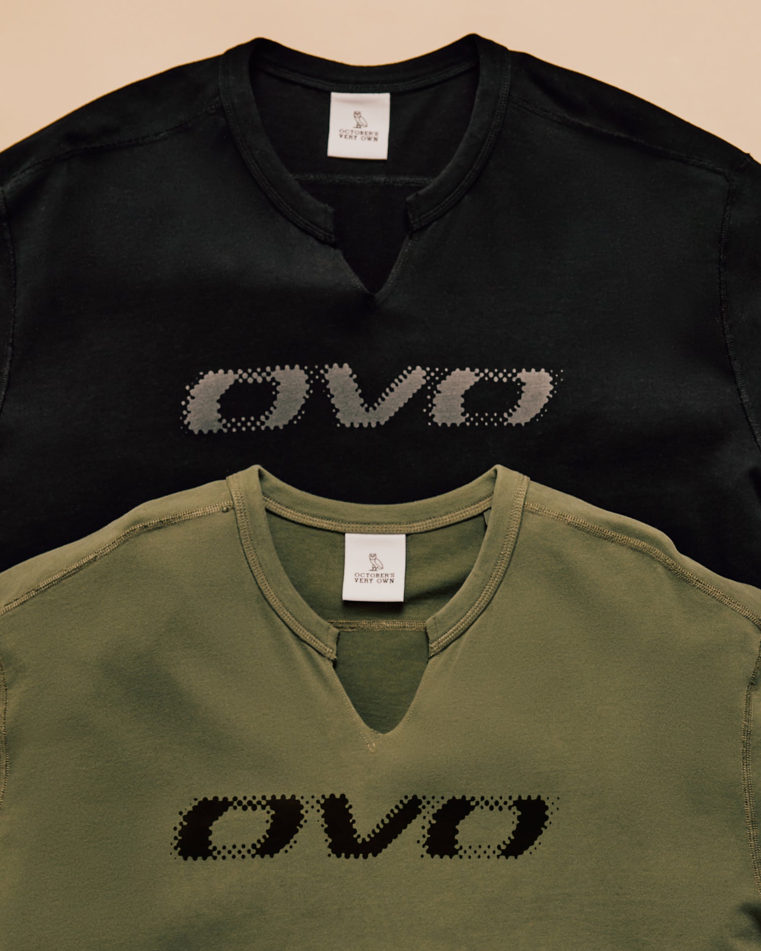 Black and green V-neck shirts with 'OVO' logo on a beige background