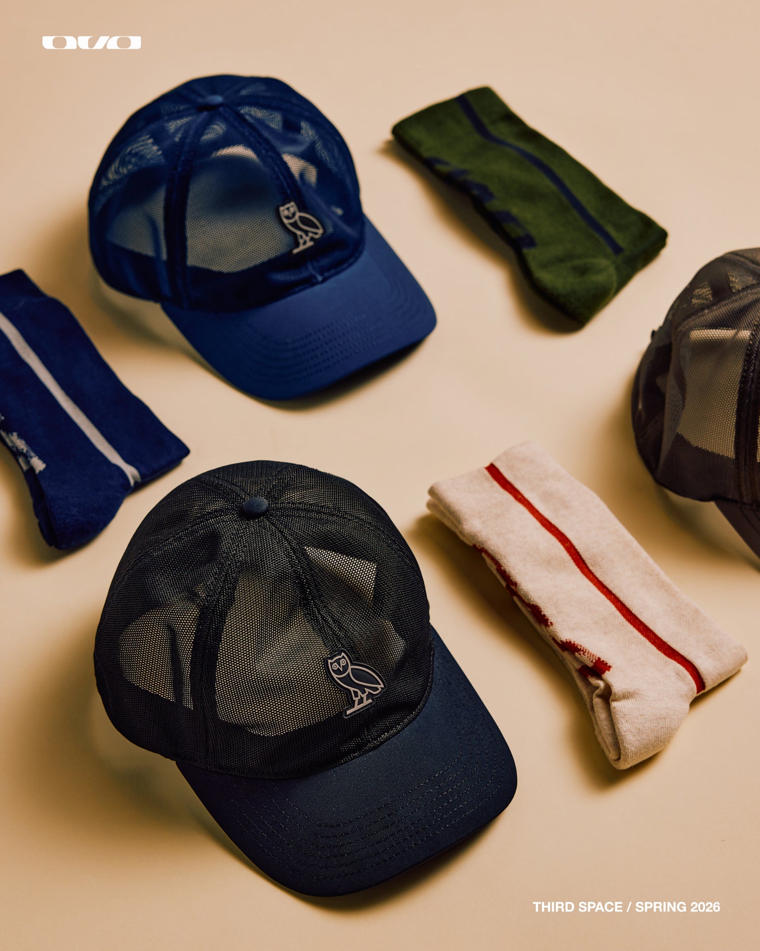 Collection of caps and headbands on a beige background with October’s Very Own branding.