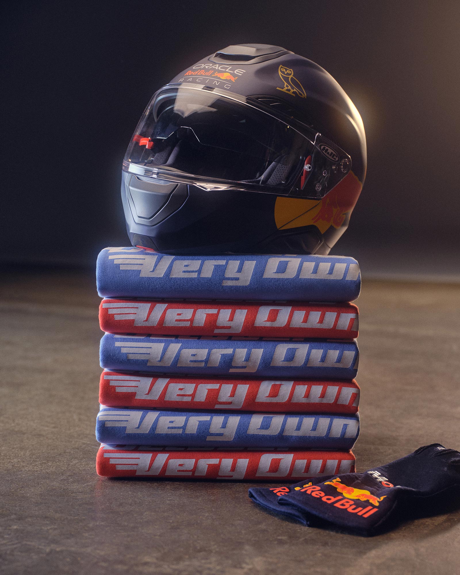 Red Bull Racing Helmet on top of stacked  October's Very Own x Red Bull Racing crewneck sweaters