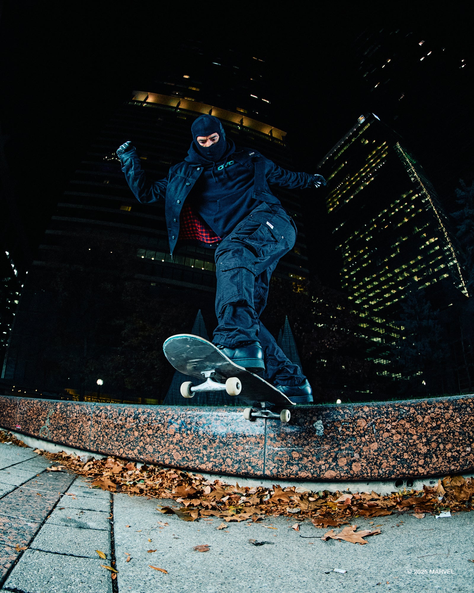 Person skateboarding at night in an urban setting with illuminated buildings in the background.