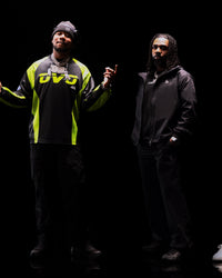 Translation missing: fr.Two individuals wearing jackets with visible branding against a dark background