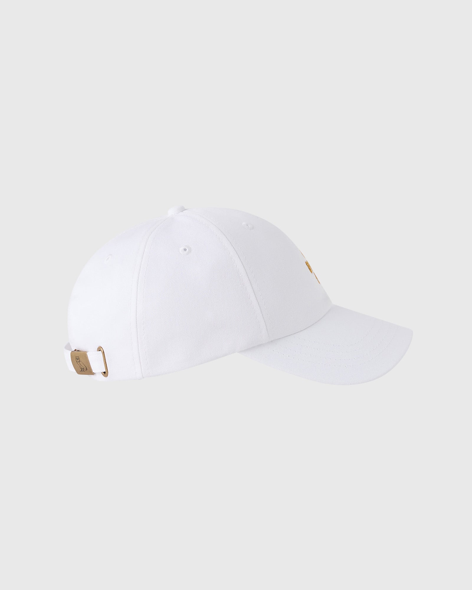 White baseball cap with pom pom on crown, tan adjustable back strap with metal hardware.