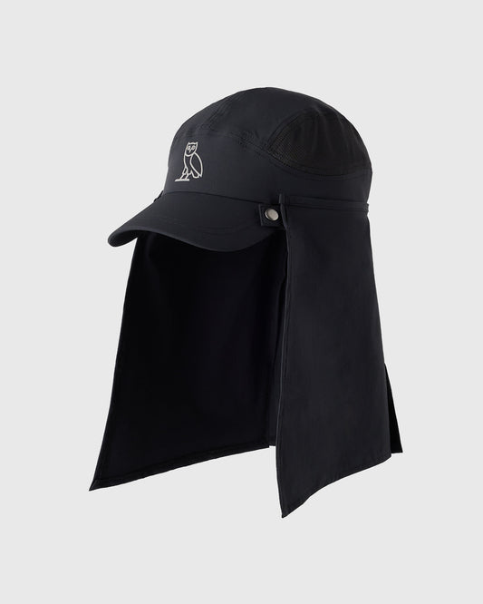 Black golf cap with extended neck shield and owl logo embroidered on front.