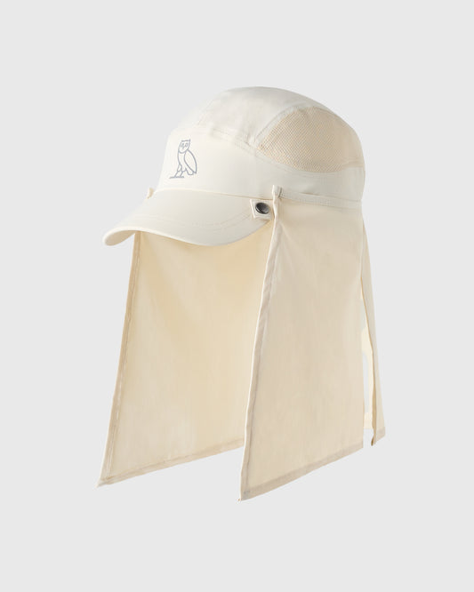 Antique white golf cap with detachable neck shield and OVO owl logo embroidered on front.