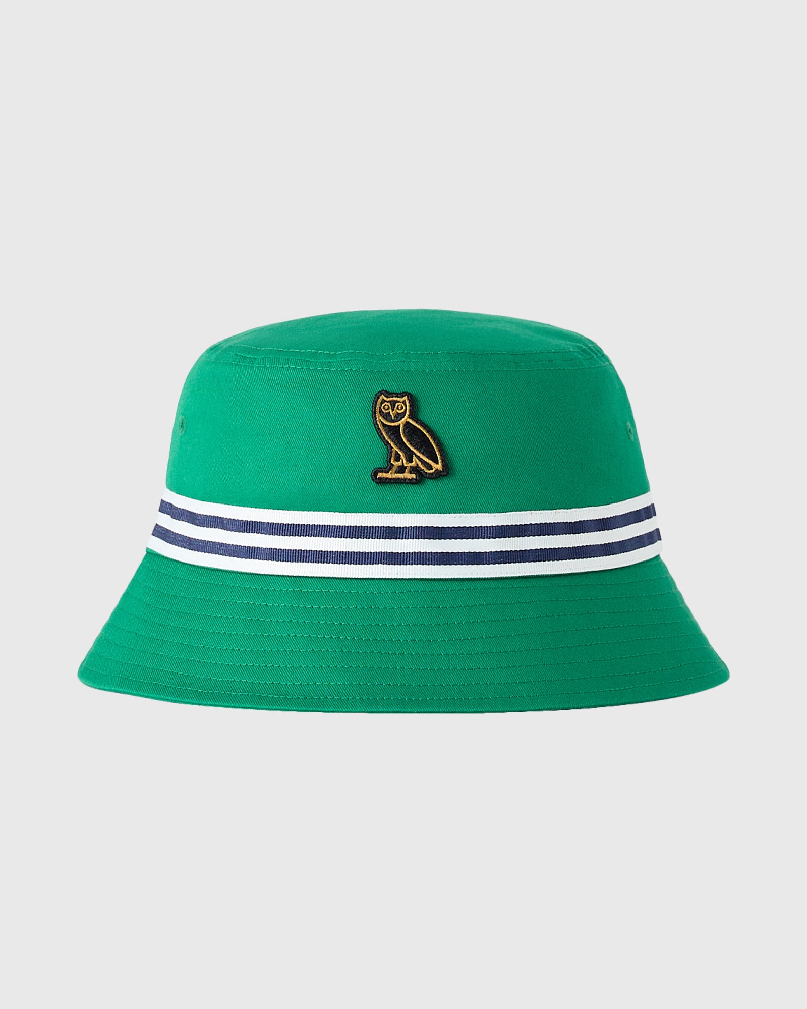 Green bucket hat with gold owl emblem and navy-white striped band around crown.